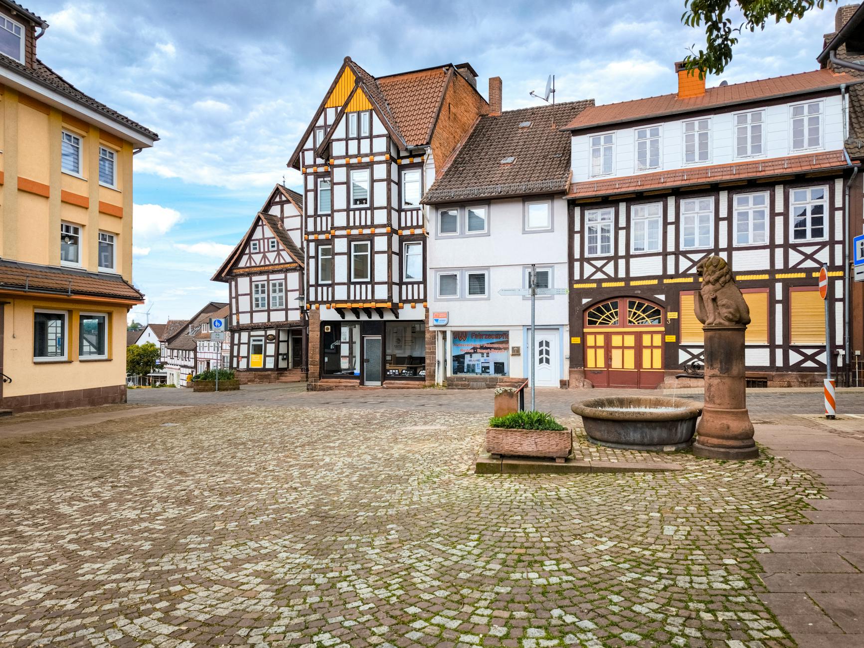 Quaint cobblestone square with traditional European architecture in a serene setting.