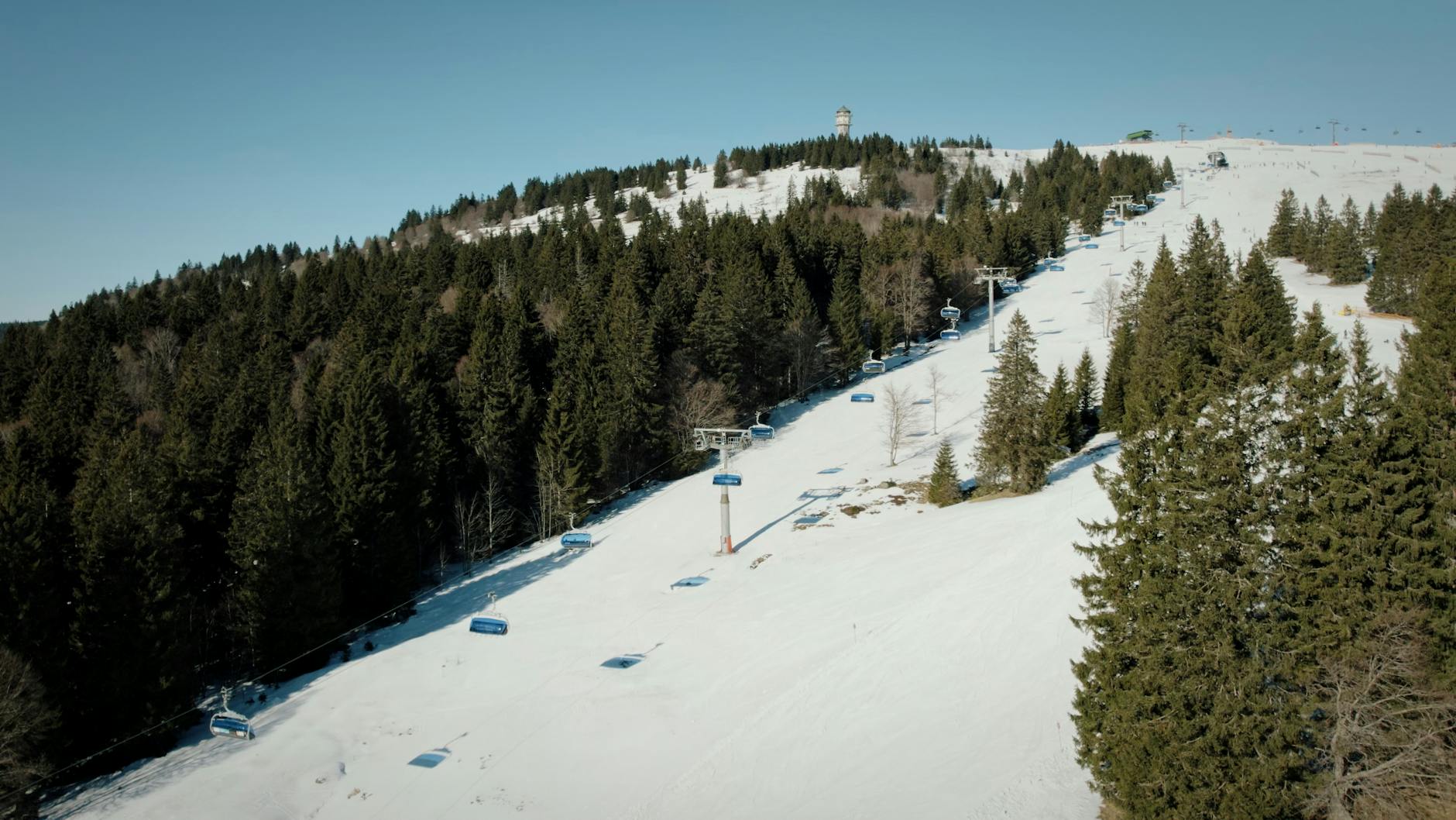 Aerial view of snowy forest and ski lift at Feldberg, Germany, during winter.